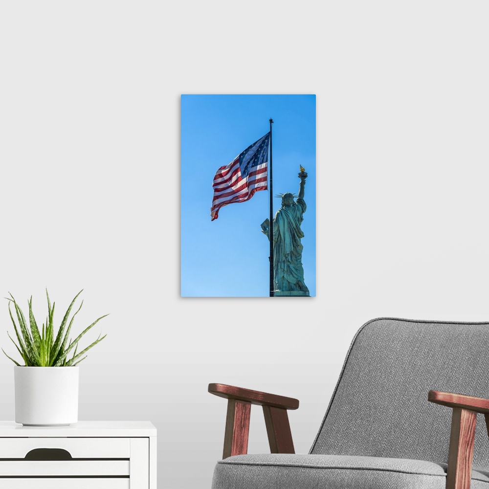 A modern room featuring Rear side of Statue of Liberty with US flag, Liberty Island, New York, USA