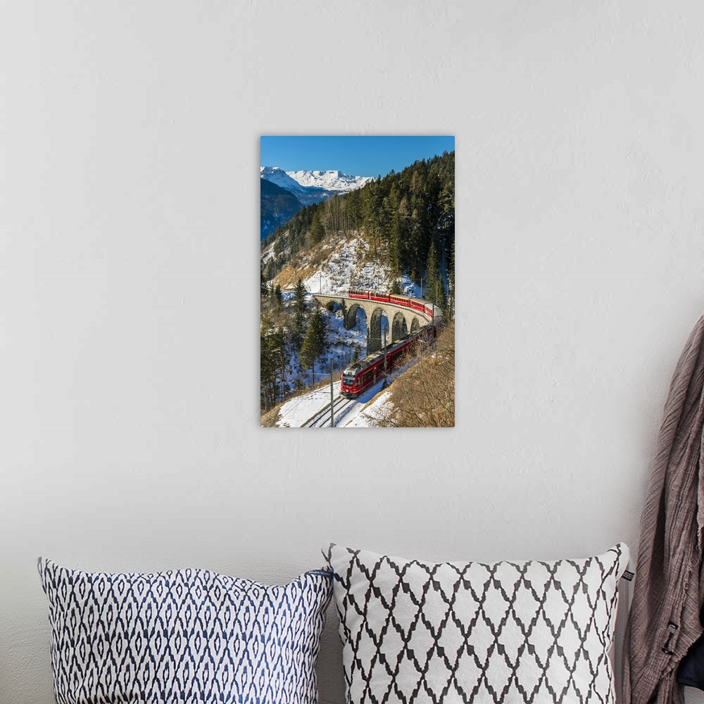 A bohemian room featuring The famous red train of Albula mountain railway passing through a scenic winter alpine landscape ...