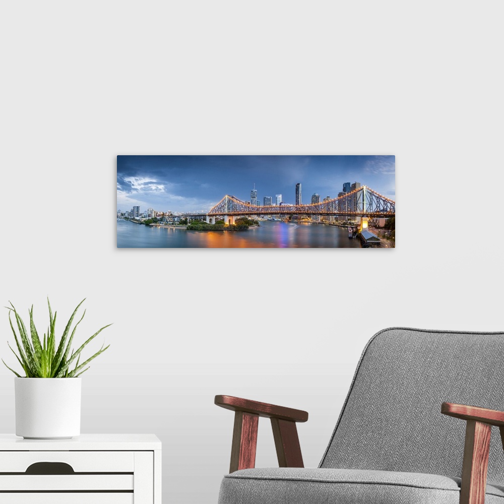 A modern room featuring Colourful reflections in the Brisbane River as storm clouds gather over the Story bridge and the ...