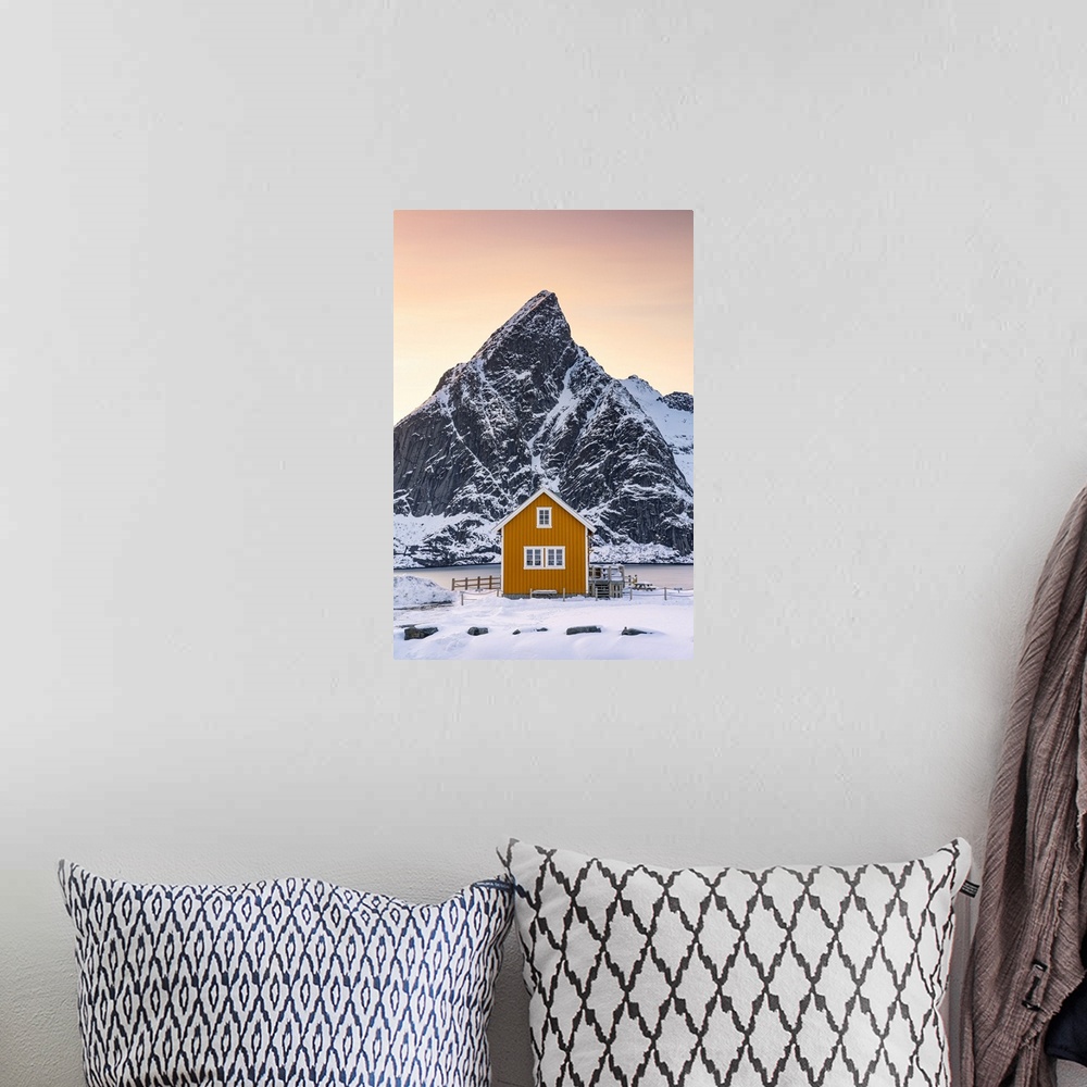 A bohemian room featuring Yellow Rorbu with majestic Olstind peak covered with snow on background, Sakrisoy, Reine, Nordlan...