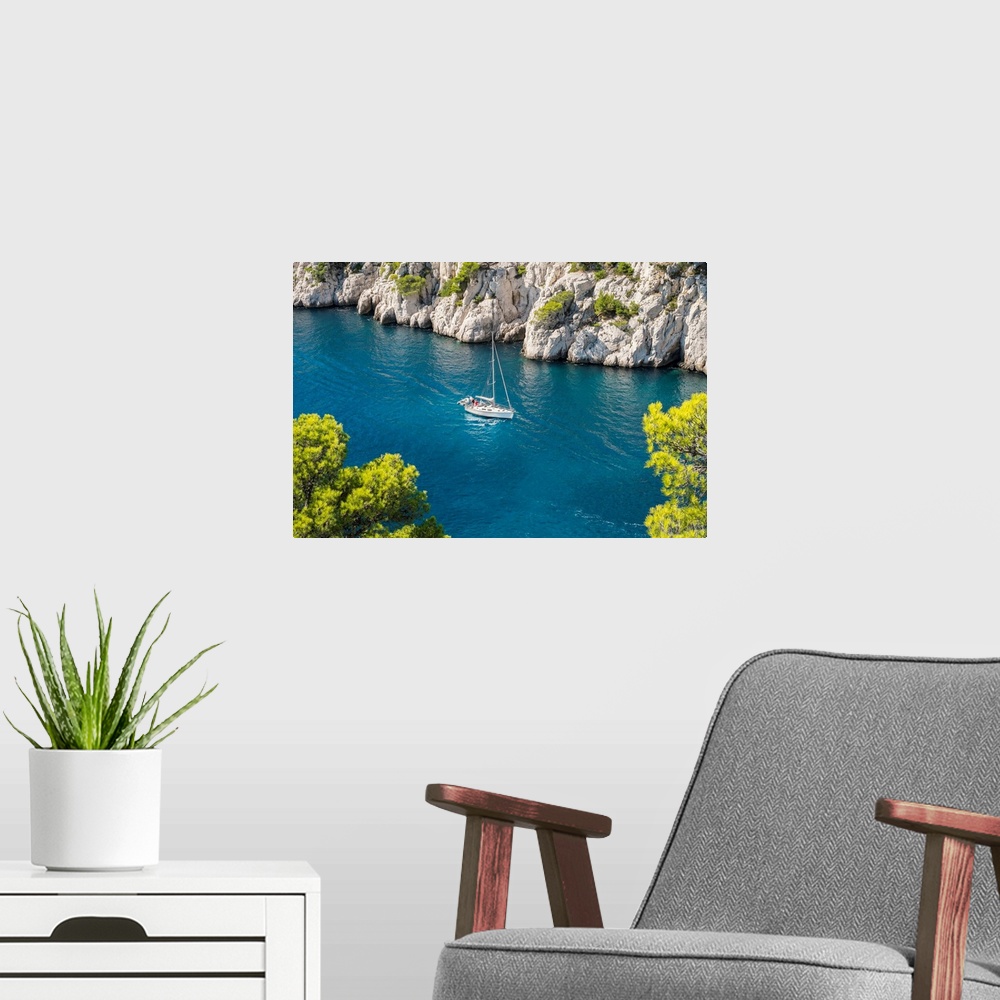 A modern room featuring Sailboat passing through emerald blue water of Calanque de Port-Pin, Cassis, Bouches-du-Rhone, Pr...