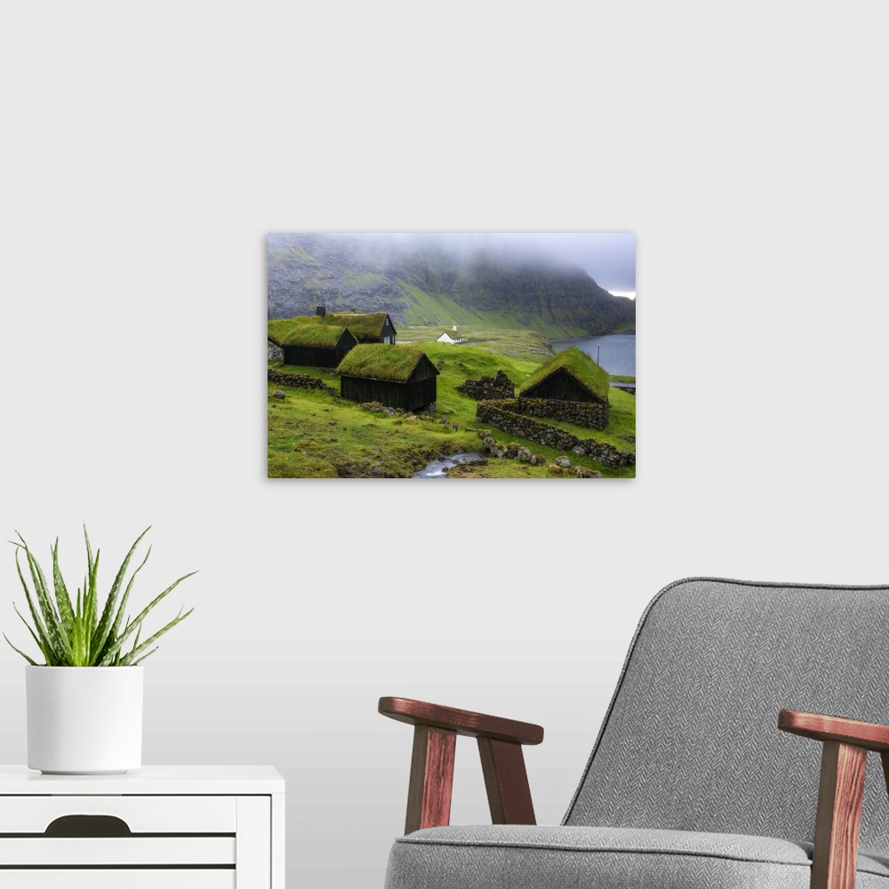 A modern room featuring Saksun, Stremnoy island, Faroe Islands, Denmark. Iconic green roof houses.