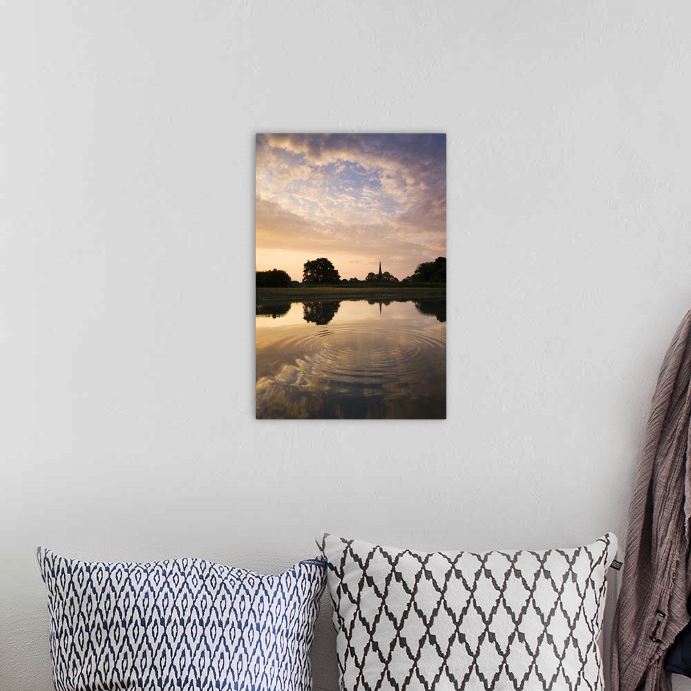 A bohemian room featuring Salisbury Cathedral Spire and a beautiful dawn sky reflected in a rippled pond, Salisbury, Wiltsh...