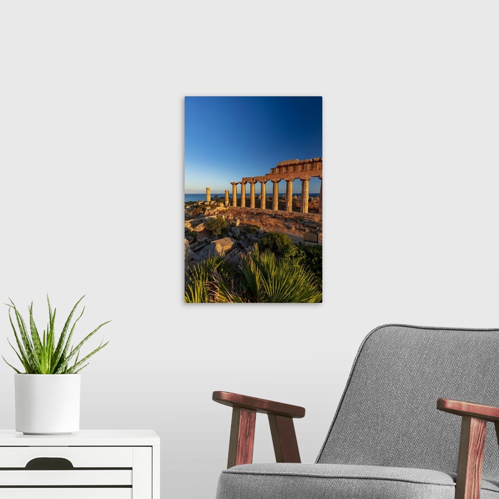 A modern room featuring Selinunte, Sicily. Greek temple at sunset with the sea in the background