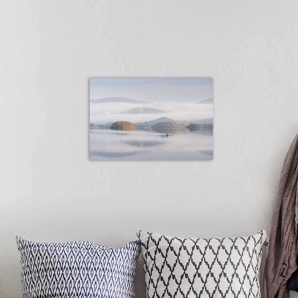 A bohemian room featuring Single sculler rowing across a misty Derwent Water at dawn, Lake District, Cumbria, England. Autu...