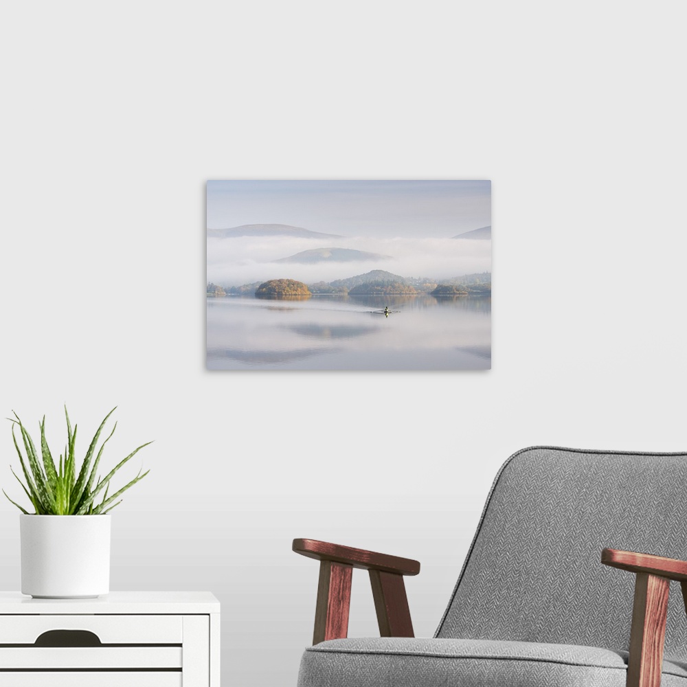 A modern room featuring Single sculler rowing across a misty Derwent Water at dawn, Lake District, Cumbria, England. Autu...