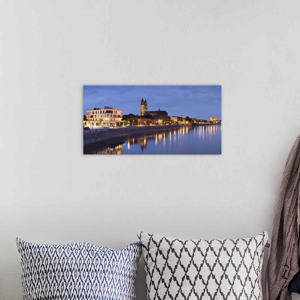 A bohemian room featuring St Mauritius and St Katharina Cathedral and River Elbe at dusk, Magdeburg, Saxony-Anhalt, Germany.