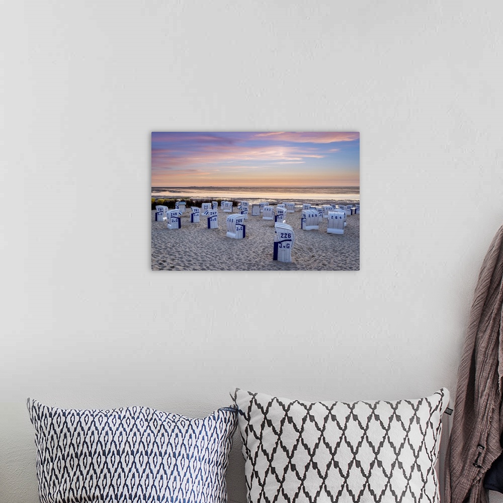 A bohemian room featuring Duhnen, Cuxhaven, Lower Saxony, Germany. Strandkorb beach chairs and the Wadden Sea at sunset.
