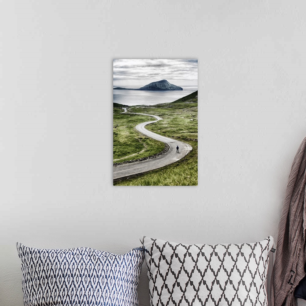 A bohemian room featuring Stremnoy island, Faroe Islands, Denmark. Man standing on a bending road.
