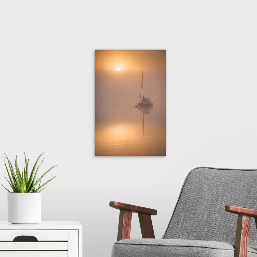 A modern room featuring Sun rising over a sailing boat moored on a misty Wimbleball Lake, Exmoor National Park, Somerset,...