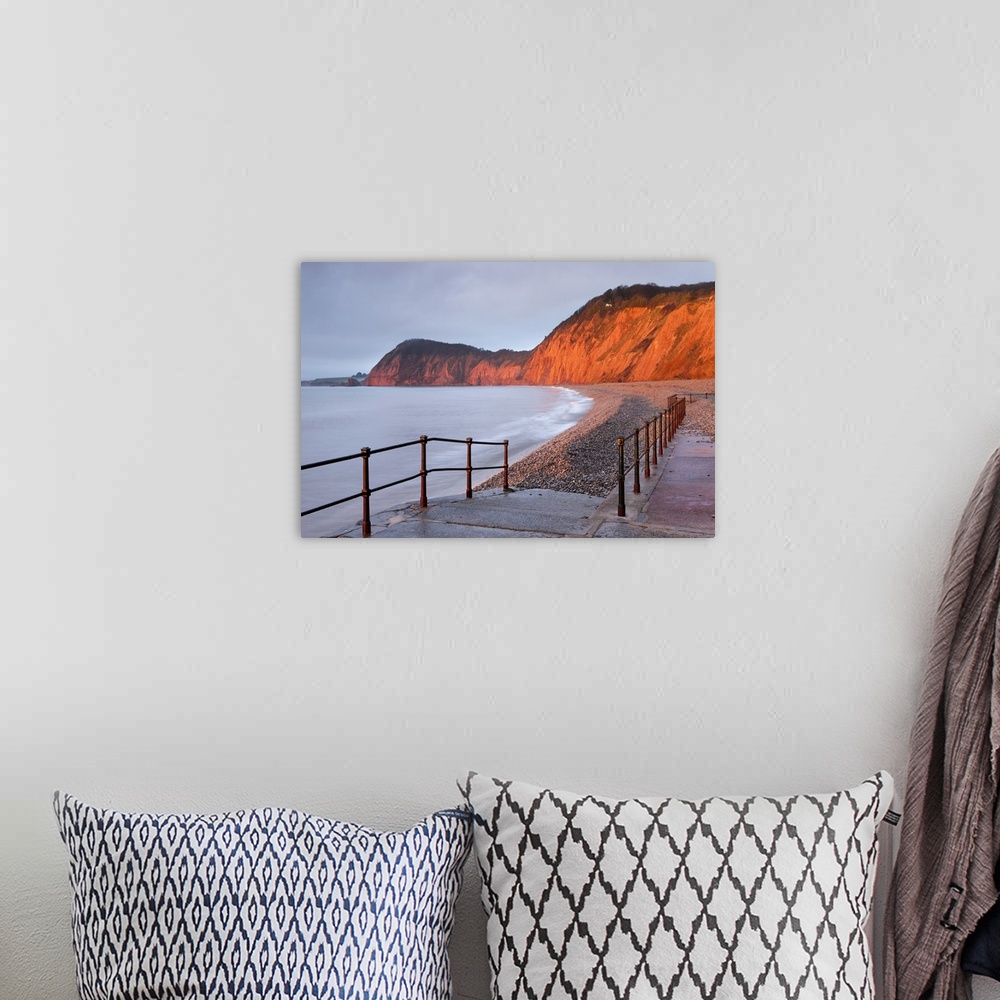 A bohemian room featuring Early morning sunlight glows against the distinctive red cliffs of High Peak, viewed from the bea...