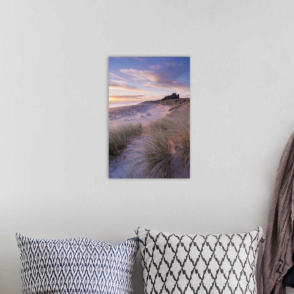 A bohemian room featuring Sunrise over Bamburgh Beach and Castle from the sand dunes, Northumberland, England. Spring (March)
