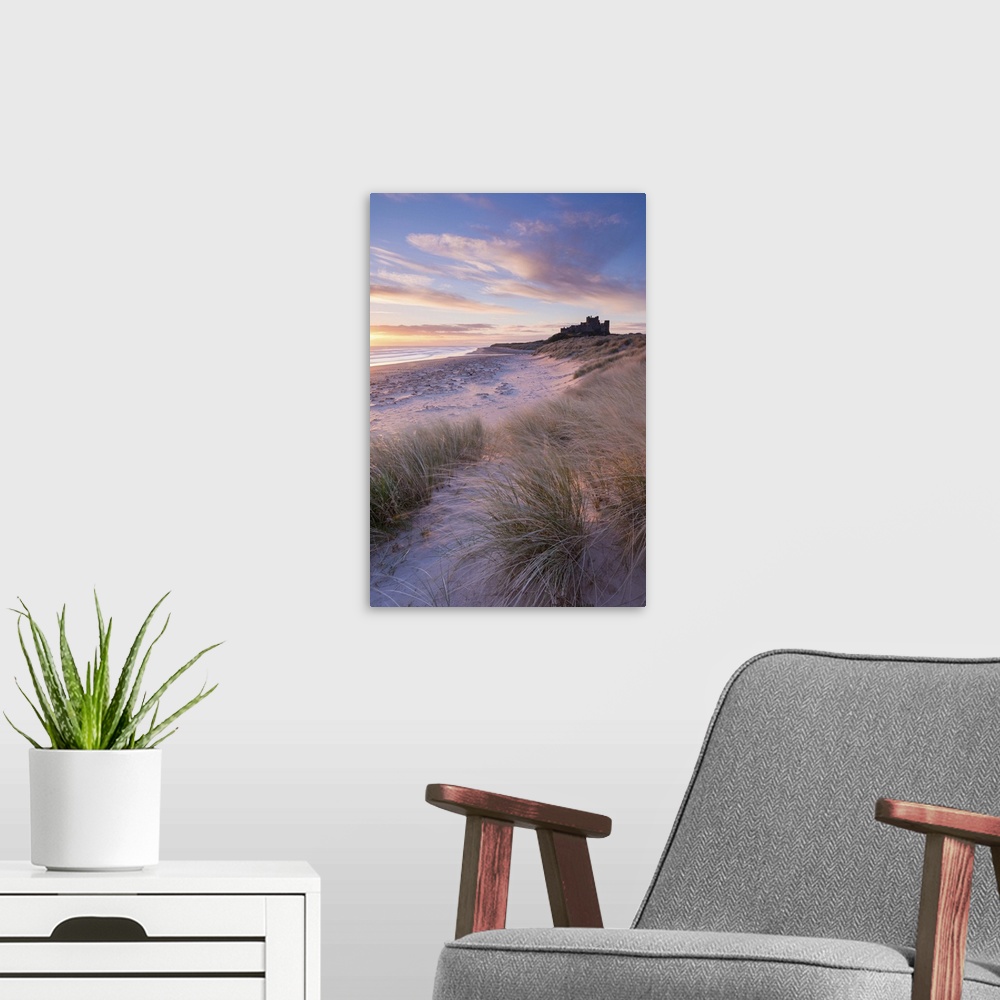 A modern room featuring Sunrise over Bamburgh Beach and Castle from the sand dunes, Northumberland, England. Spring (March)