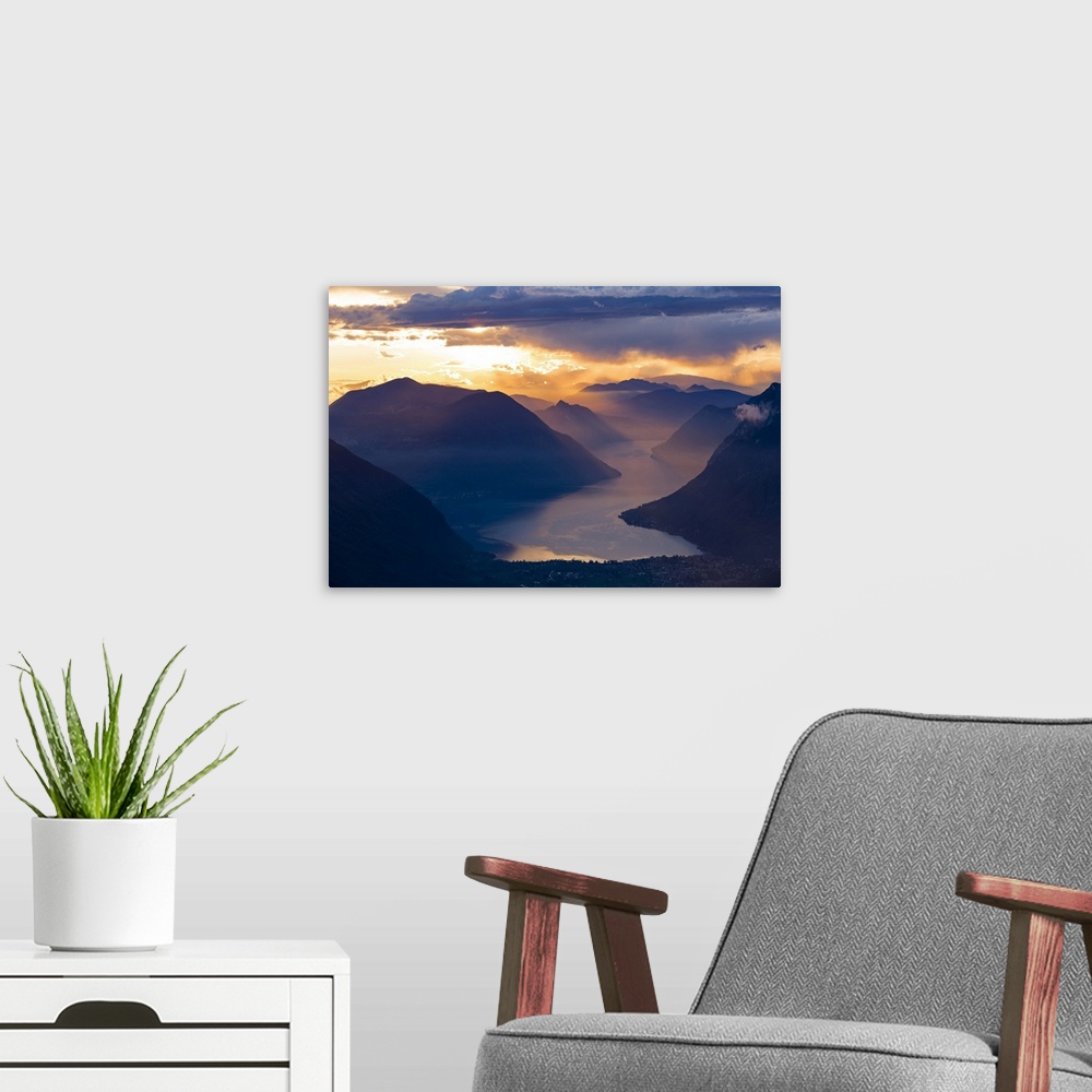 A modern room featuring Sunset over the mountains and the lake Lugano, Switzerland