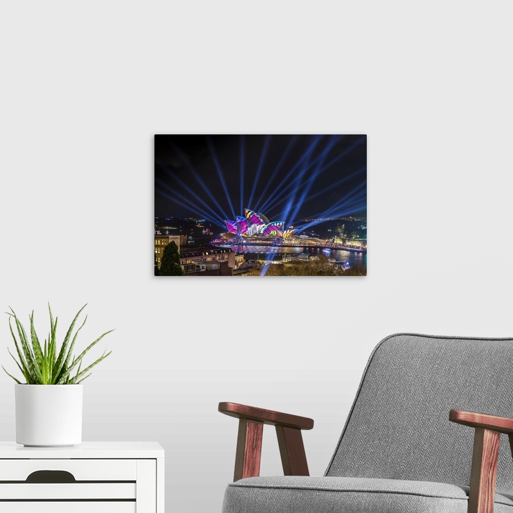A modern room featuring Sydney Opera House illuminated with lasers and projections during Vivid Sydney festival, Sydney, ...