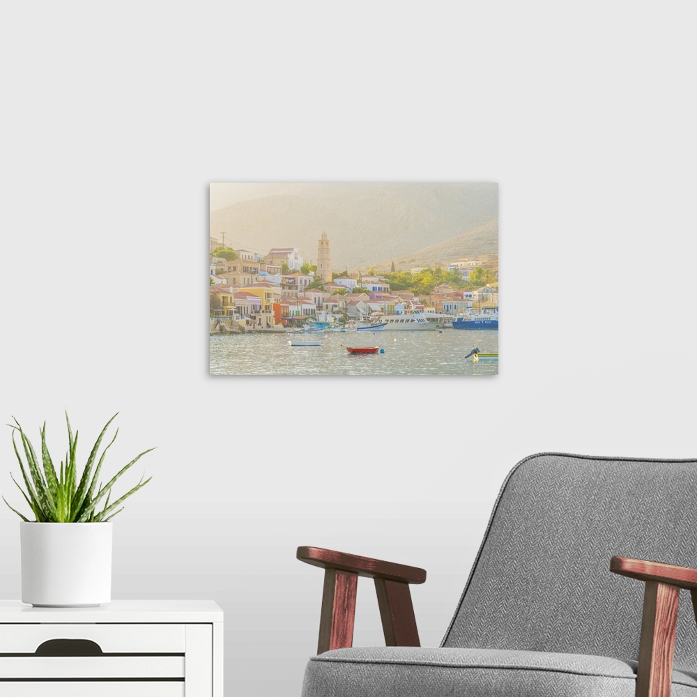 A modern room featuring The colourful harbour and Saint Nicholas church in the background, Halki, Chalki, Dodecanese Isla...