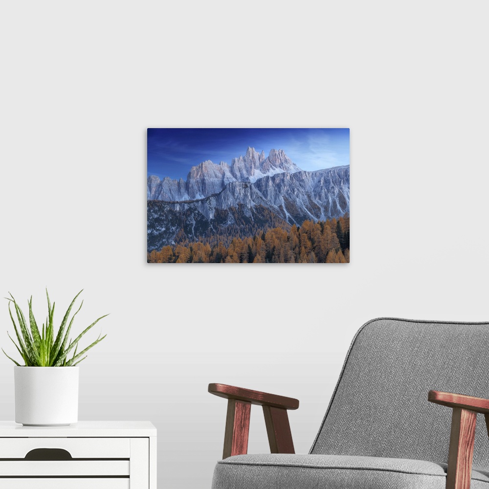 A modern room featuring The Croda da Lago and Lastoi de Formin mountains at twilight, with the golden larches glowing in ...