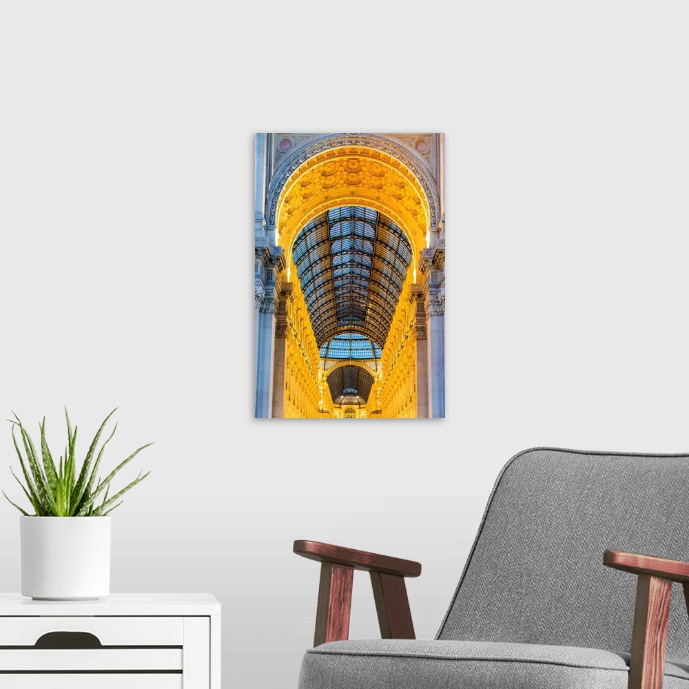 A modern room featuring Milan, Lombardy, Italy. The entrance to the Galleria Vittorio Emanuele II illuminated at dusk.