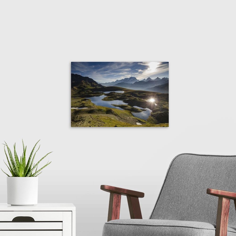A modern room featuring The Rosset lake and Leia lake appearing in the first summer's morning light, with Gran Paradiso m...