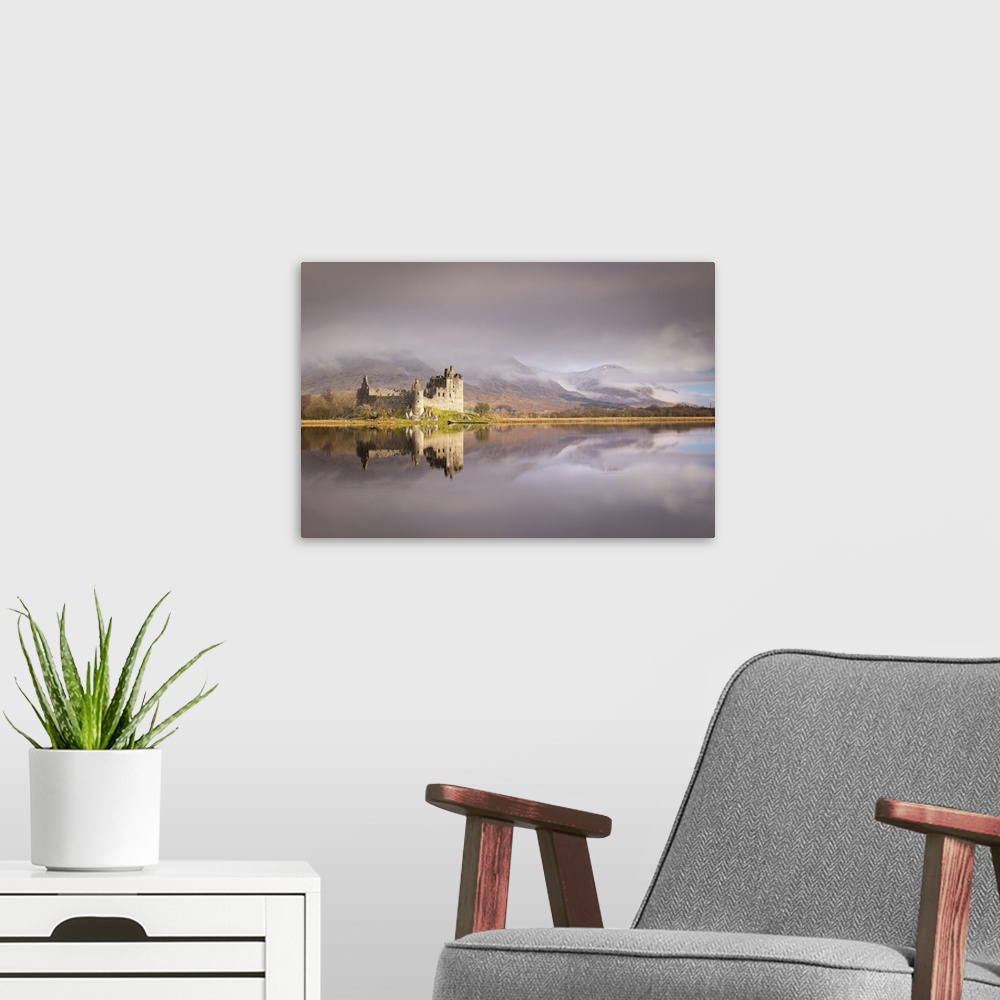 A modern room featuring The ruins of Kilchurn Castle reflected in Loch Awe at dawn on a misty morning in the Scottish Hig...