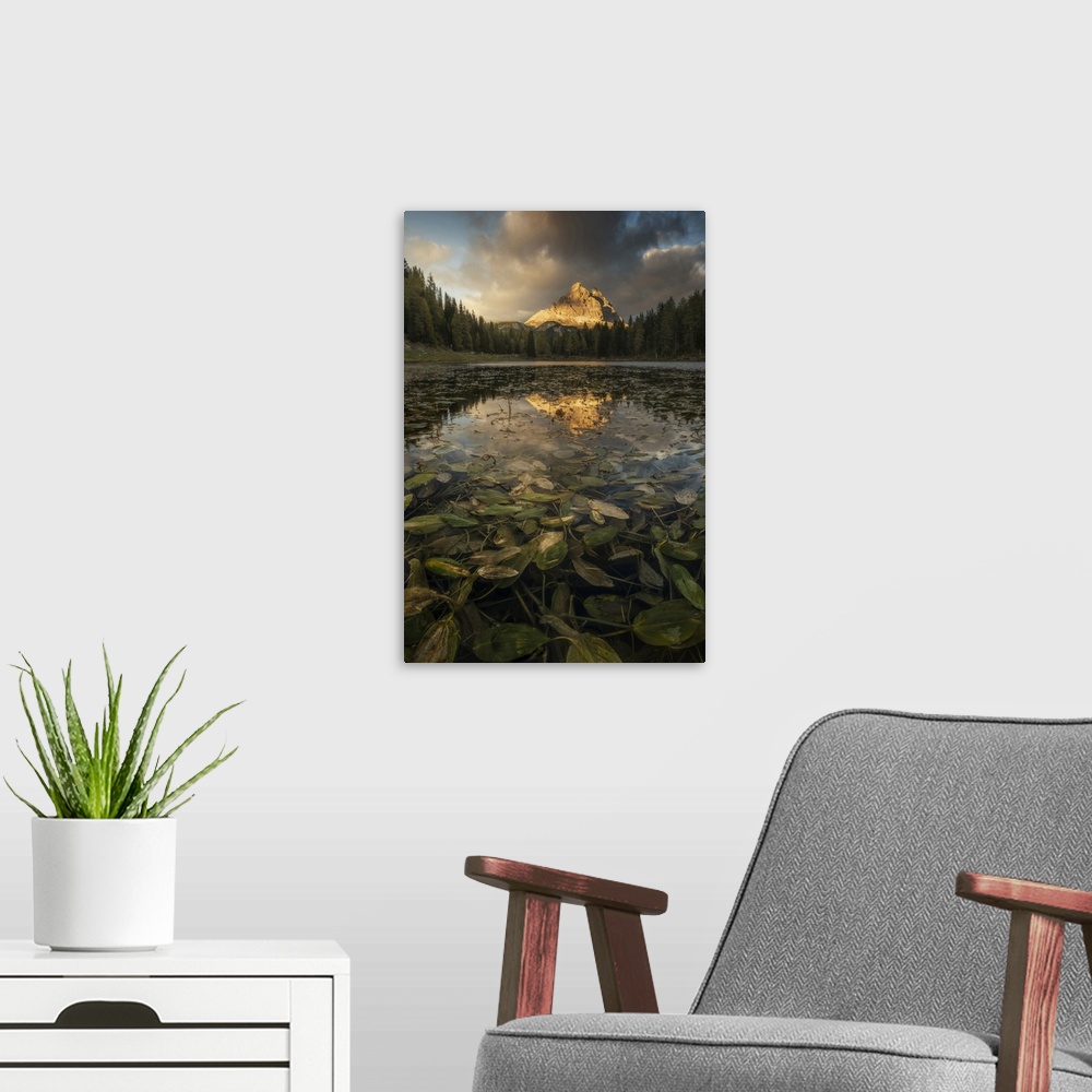A modern room featuring The Tre Cime di Lavaredo reflecting in the Antorno lake during an early autumn sunset, with some ...