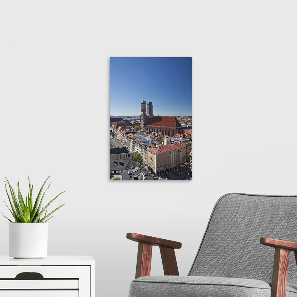 A modern room featuring The twin towers of the Munich Frauenkirche and the Marianplatz viewed from the steeple of St. Pet...