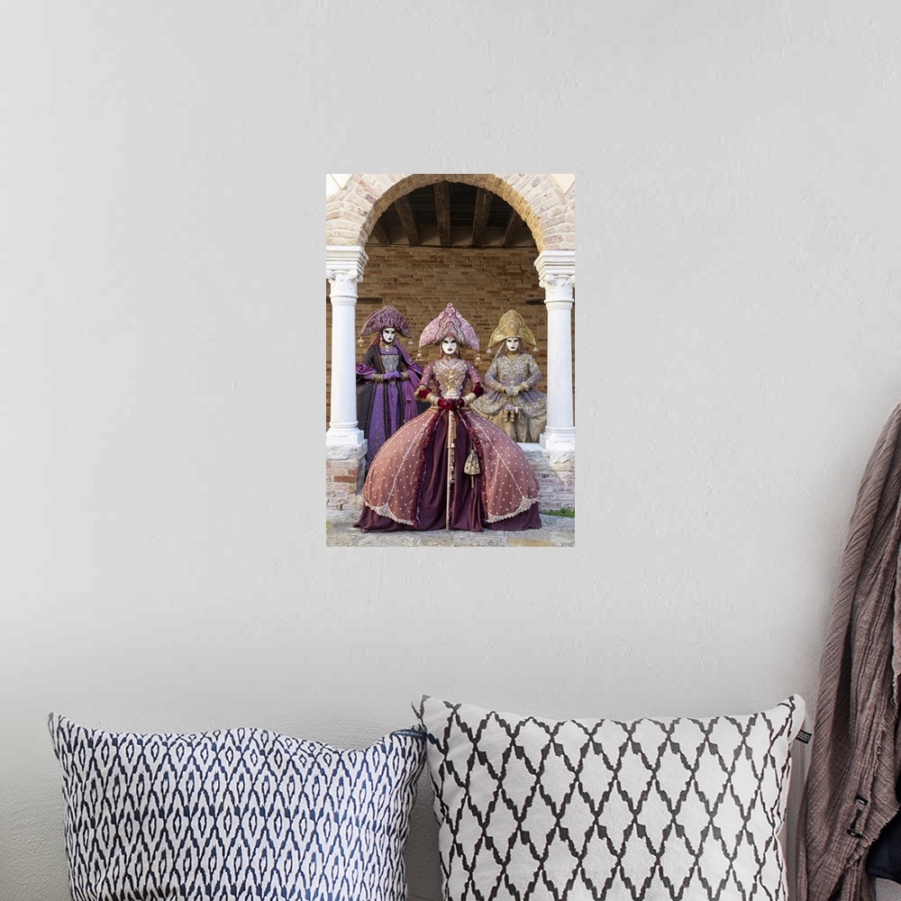 A bohemian room featuring Three women wearing Indian style costumes and masks pose in the cloisters of Chiesa di San France...