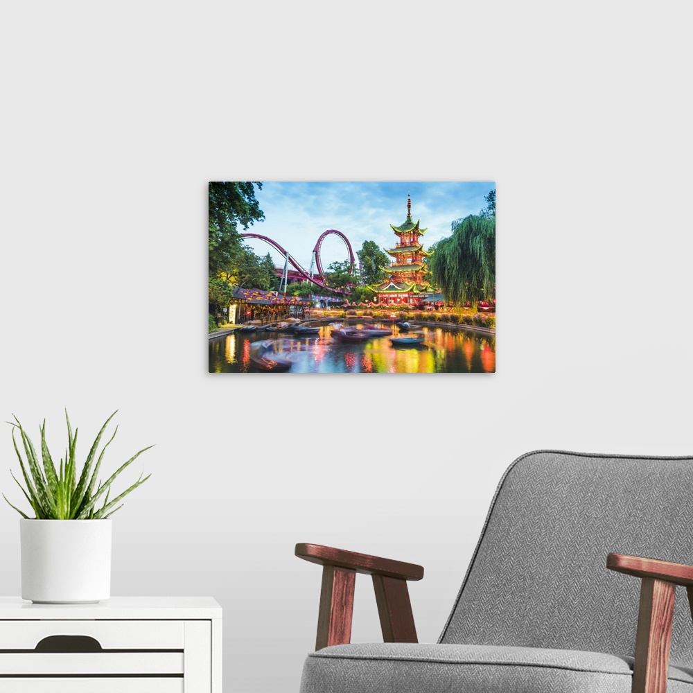 A modern room featuring Tivoli gardens, Copenhagen, Hovedstaden, Denmark. The Chinese Tower and boating lake at dusk.