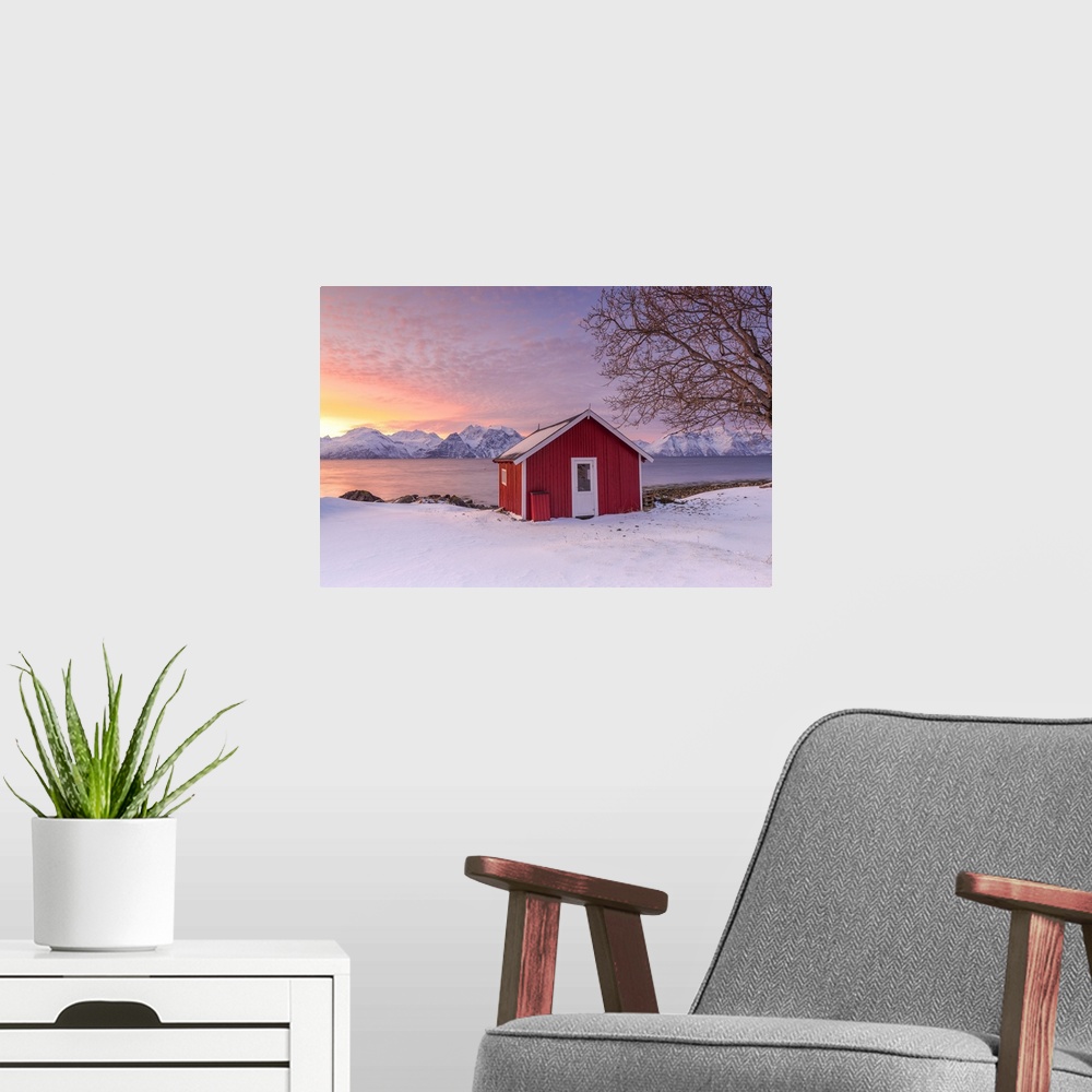 A modern room featuring Traditional Norwegian house during a sunset on the fjord. Nordmannvik, Kafjord, Lyngen Alps, Trom...