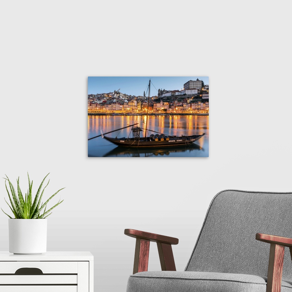 A modern room featuring Traditional Rabelo boat designed to carry wine down Douro river with city skyline behind, Porto, ...