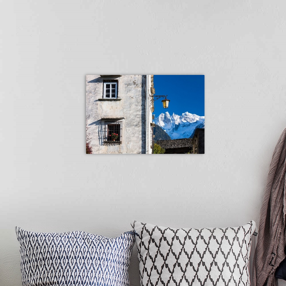 A bohemian room featuring Typical alpine house and street lantern frame the snowy peaks Soglio Bregaglia Valley canton of G...