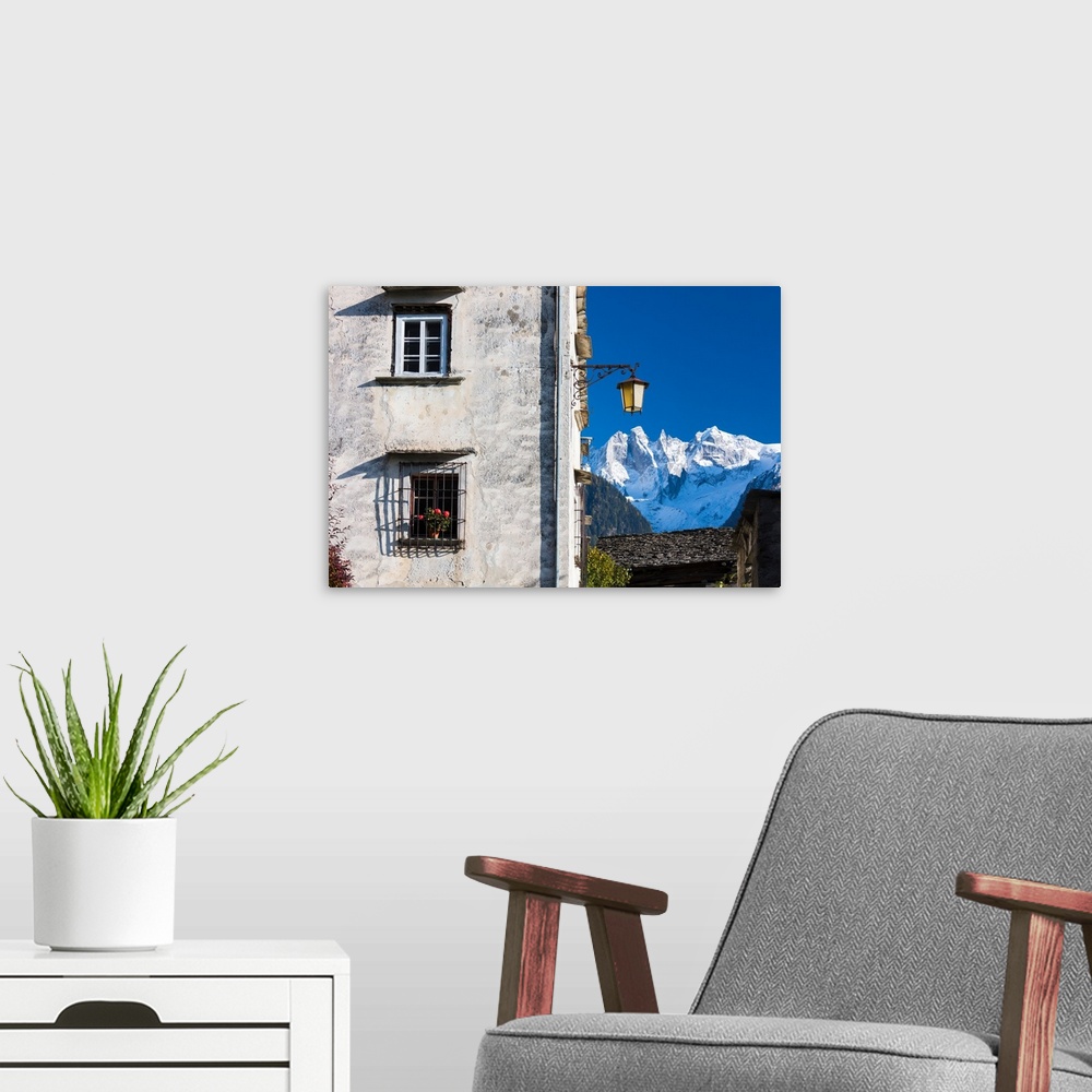 A modern room featuring Typical alpine house and street lantern frame the snowy peaks Soglio Bregaglia Valley canton of G...