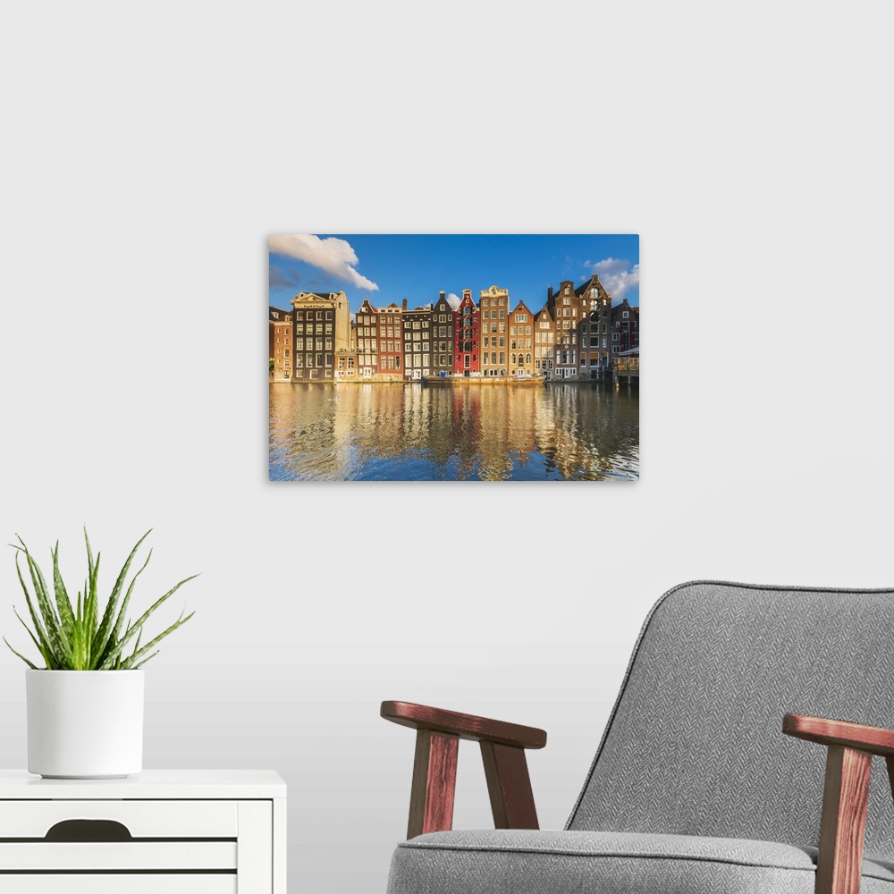 A modern room featuring Typical houses reflecting in Damrak canal at sunset, Holland/Netherlands