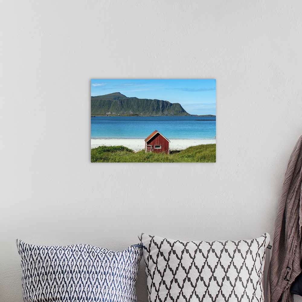 A bohemian room featuring Typical Red Rorbu On Ramberg Beach, Lofoten Islands, Norway