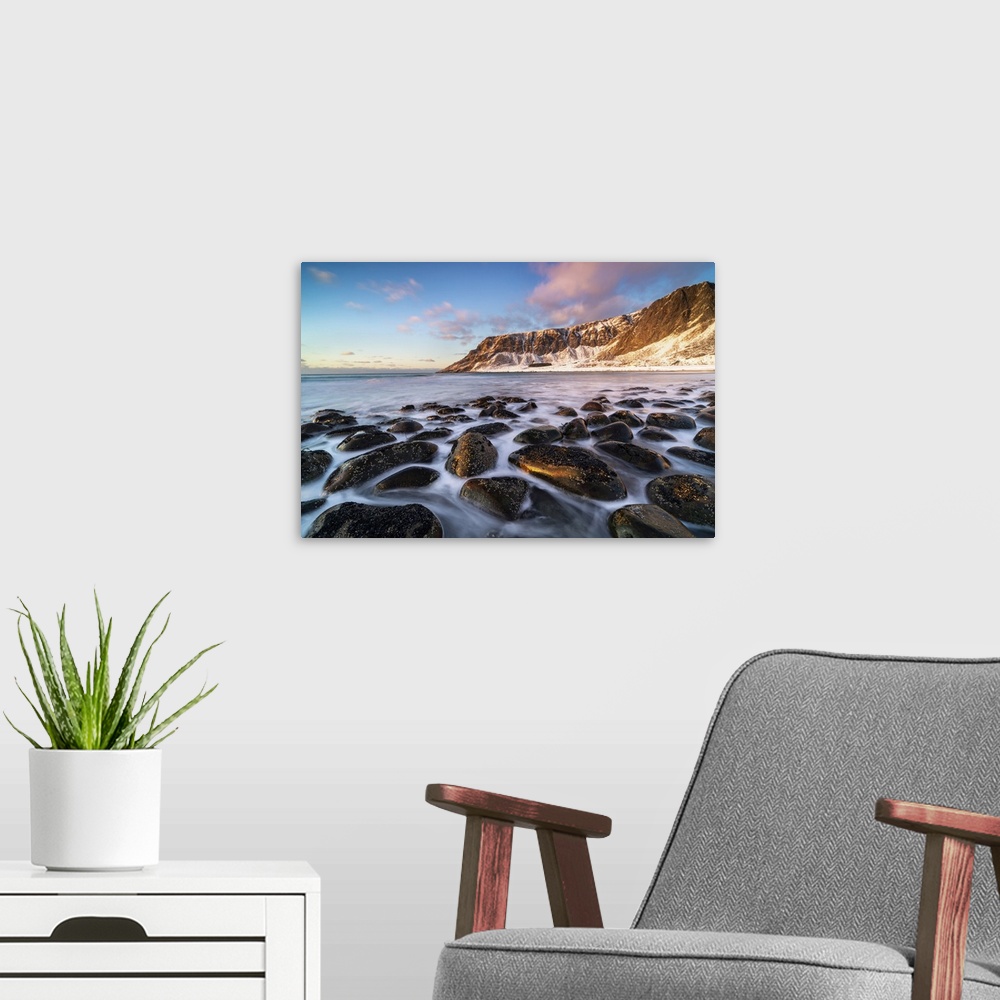 A modern room featuring Unstad Beach with Kleivheia mountain in the background in winter at sunset. Vestvagoy municipalit...