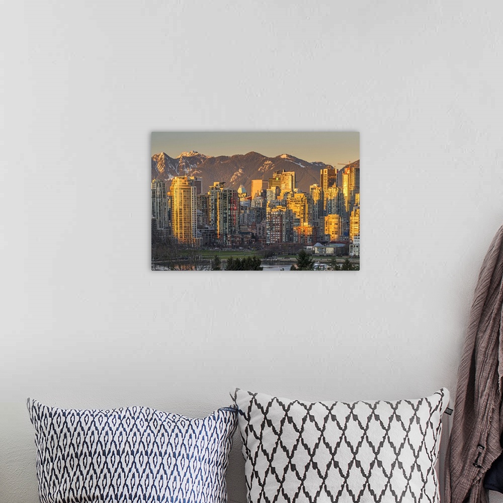 A bohemian room featuring Downtown skyline with snowy mountains behind at sunset, Vancouver, British Columbia, Canada.