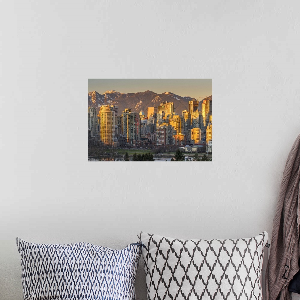 A bohemian room featuring Downtown skyline with snowy mountains behind at sunset, Vancouver, British Columbia, Canada.
