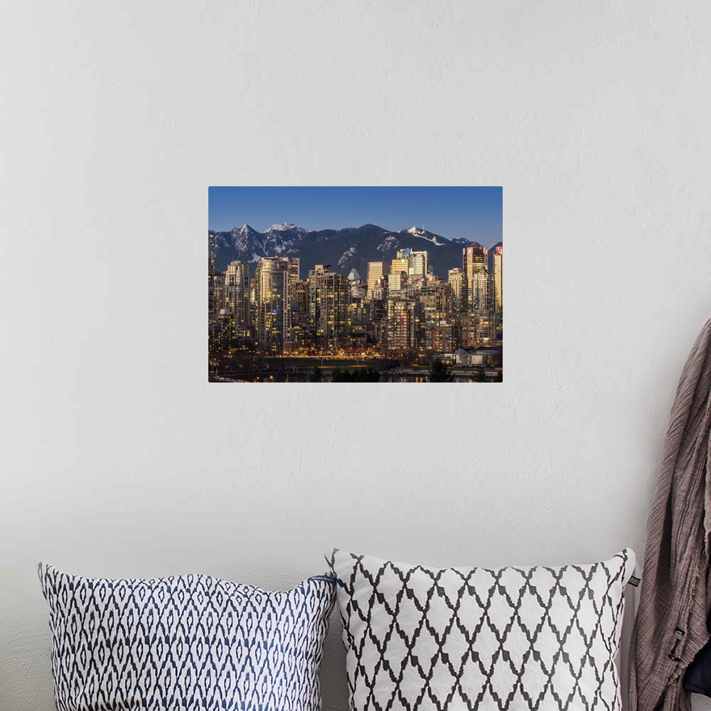 A bohemian room featuring Downtown skyline with snowy mountains behind at dusk, Vancouver, British Columbia, Canada.