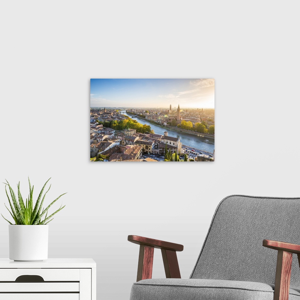 A modern room featuring Verona, Veneto, Italy. High angle view of the old town and the Adige river at sunset.