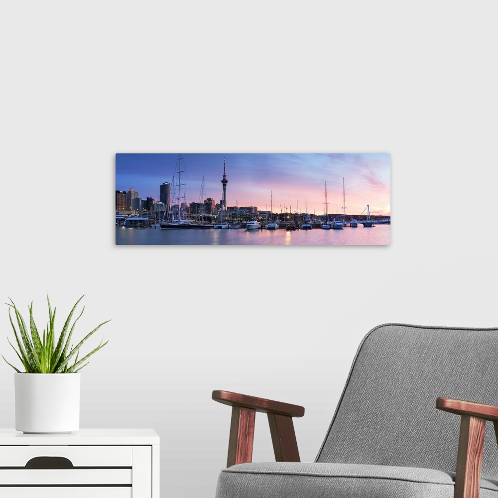 A modern room featuring Viaduct Harbour and Sky Tower at sunset, Auckland, North Island, New Zealand