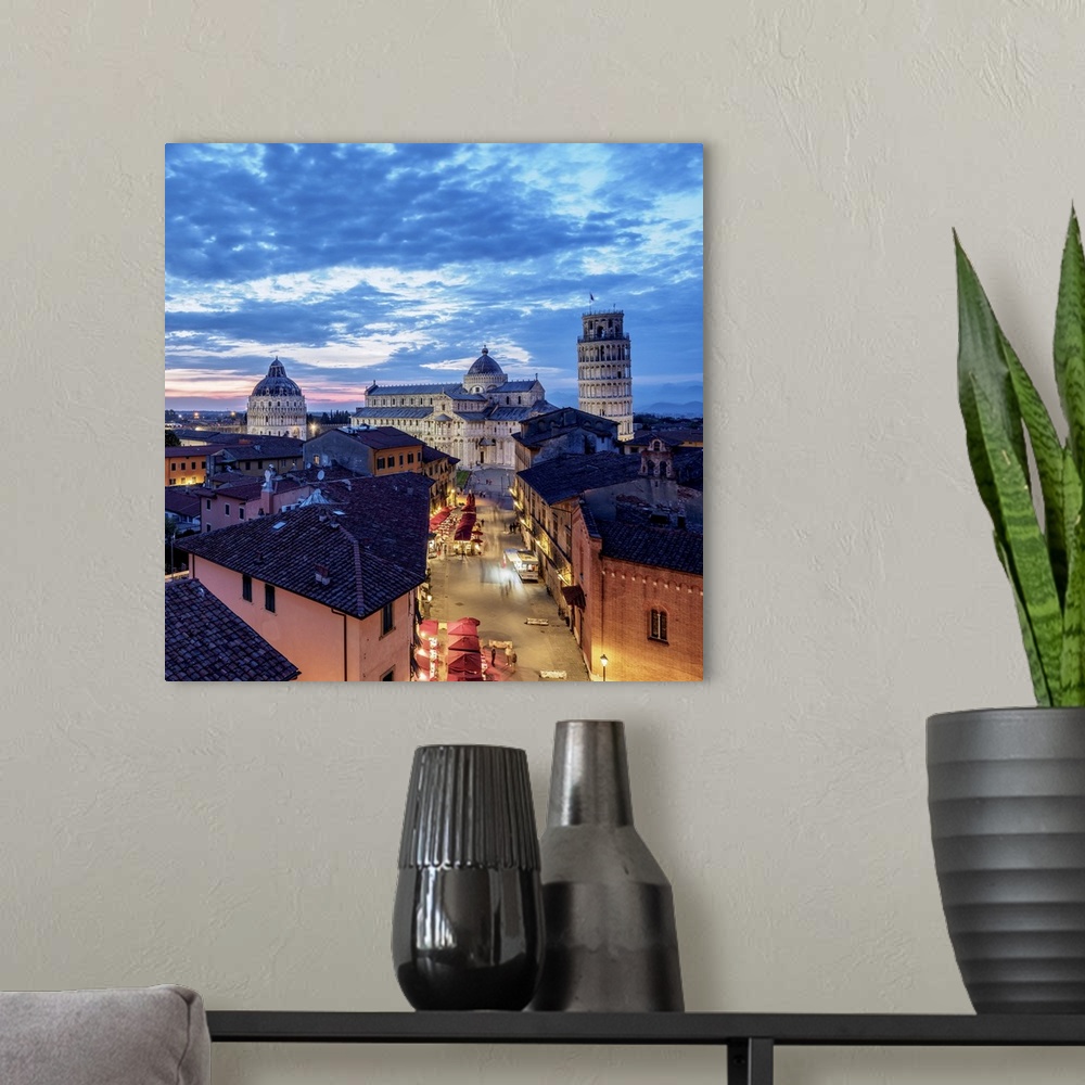 A modern room featuring View over Via Santa Maria towards Cathedral and Leaning Tower at dusk, Pisa, Tuscany, Italy.
