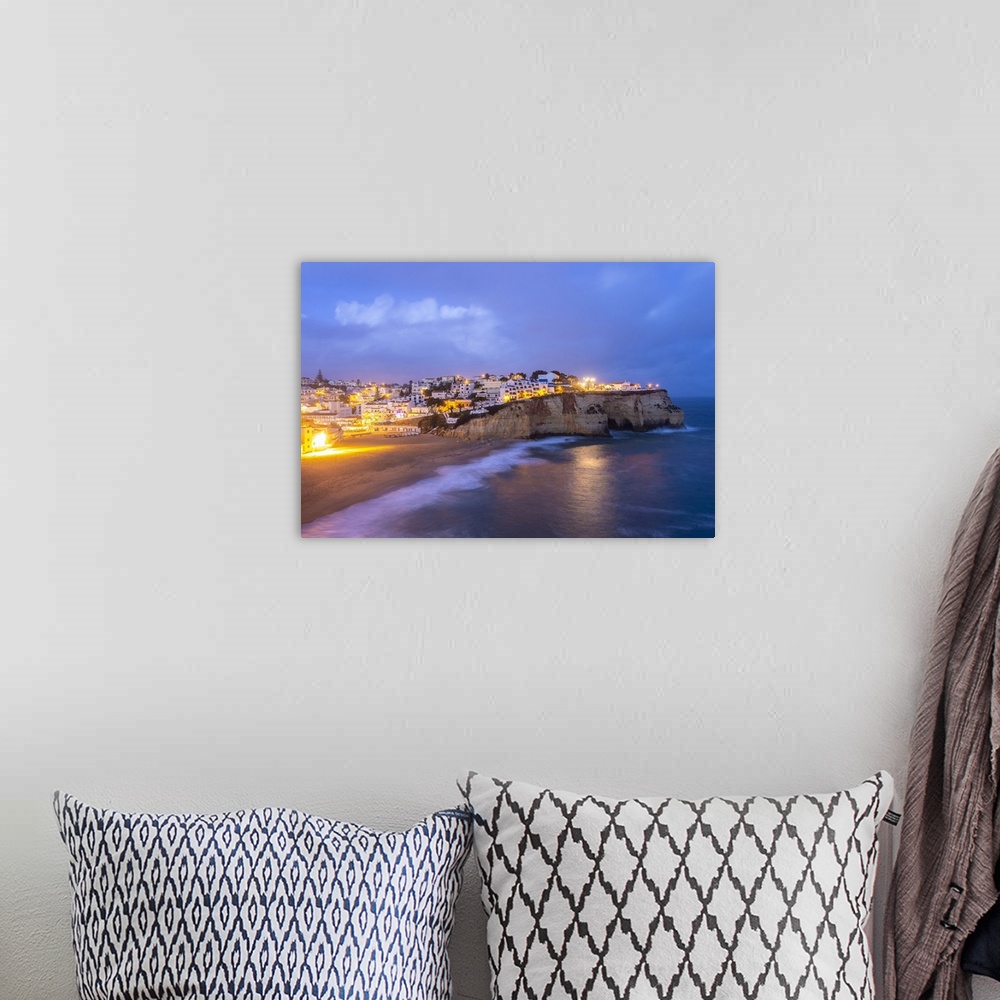 A bohemian room featuring View of the lights of the village of Carvoeiro and its beach at blue hour. Lagoa municipality, Al...