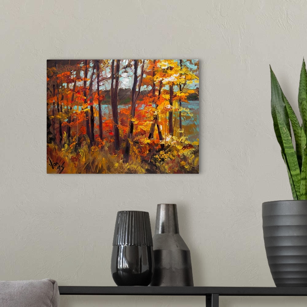 A modern room featuring Large, horizontal painting of fall colored trees creating a wall in front of a lake in the backgr...