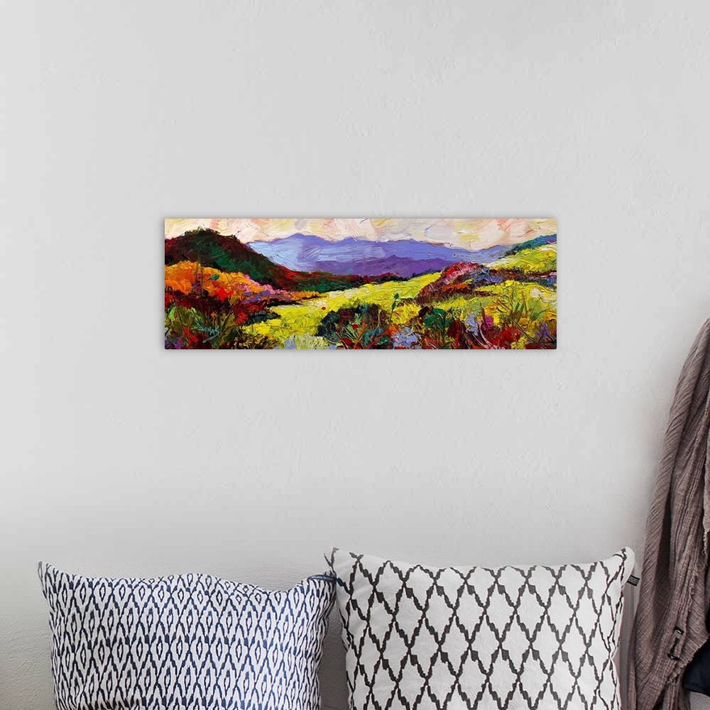 A bohemian room featuring A contemporary painting of a landscape in a wide range of colors.