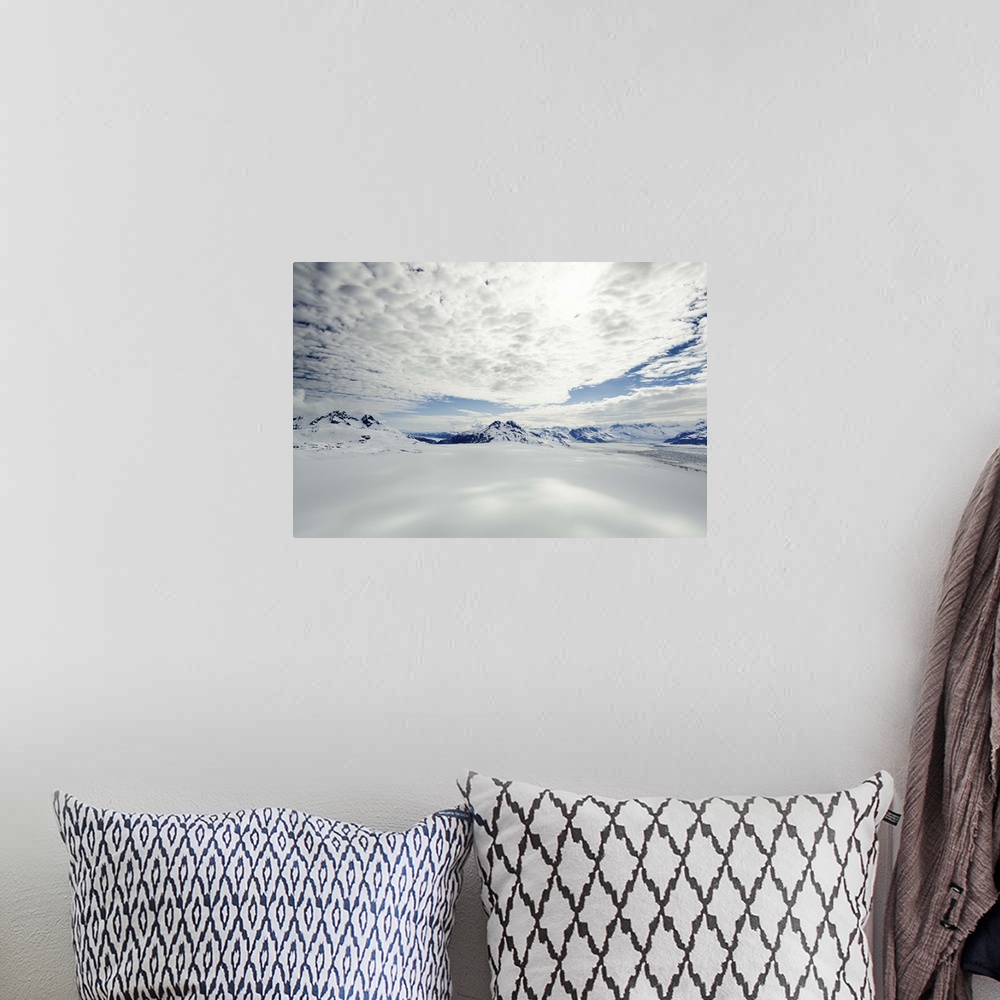 A bohemian room featuring A landscape covered in snow high in the mountains of Alaska, under a cloudy sky.