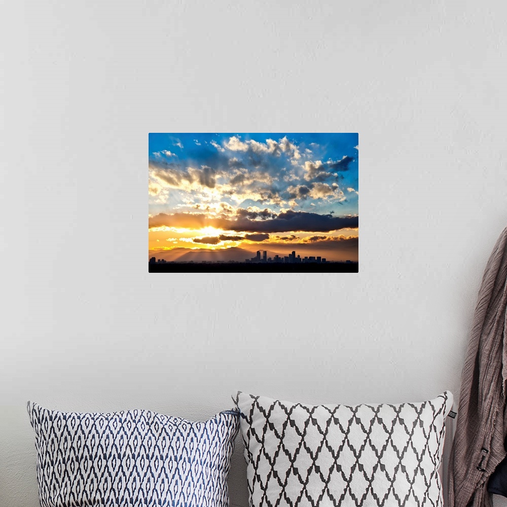A bohemian room featuring Large photograph focuses on the sun's powerful rays trying to break through a sky scattered with ...
