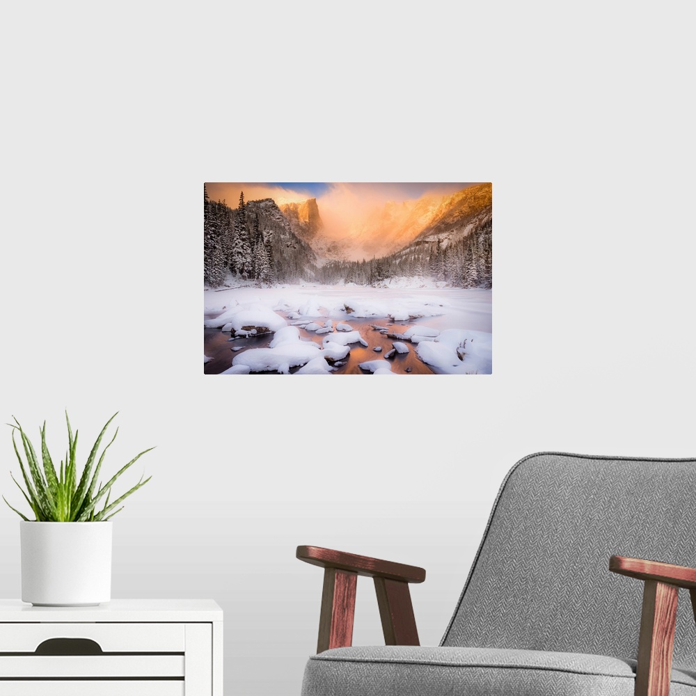 A modern room featuring Giant photograph of a snow covered landscape filled with trees surrounding and a frozen river run...