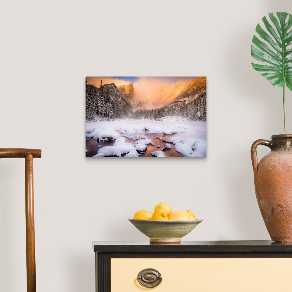 A traditional room featuring Giant photograph of a snow covered landscape filled with trees surrounding and a frozen river run...