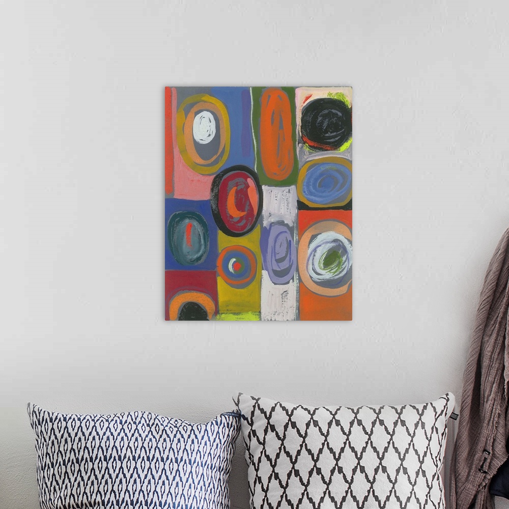A bohemian room featuring Painting of circular shapes in various hues and sizes over blocks of color.