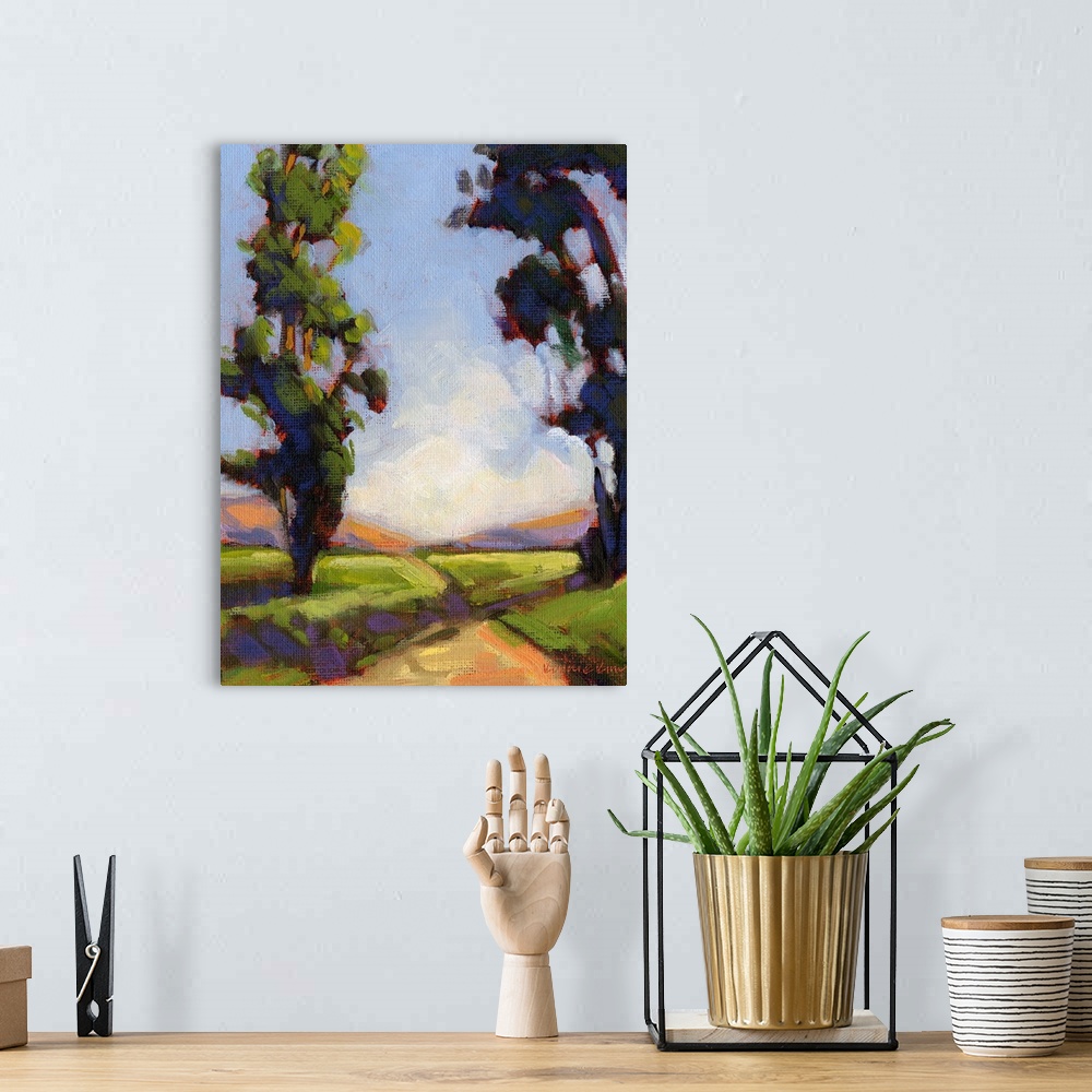 A bohemian room featuring Vertical painting of a country road framed by two large trees.